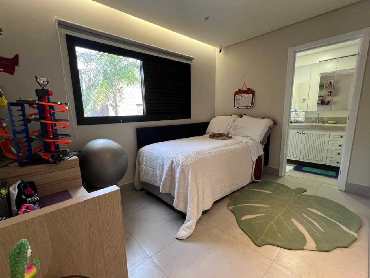 Foto original: quarto com cama, janela e porta para o banheiro